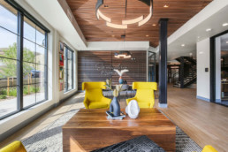 Lobby with yellow chairs and wood coffee table and a sign in the background reading So Much In Common