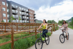 Girls riding their bike on the path in front of Basecamp