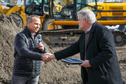 employees shaking hands at the ground breaking ceremony for a real estate development