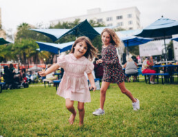 girls playing in the park along main street uai